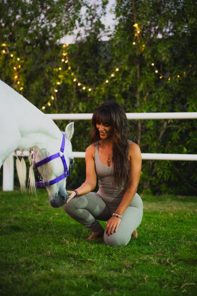 A calm moment of connection between a woman and a horse in the desert